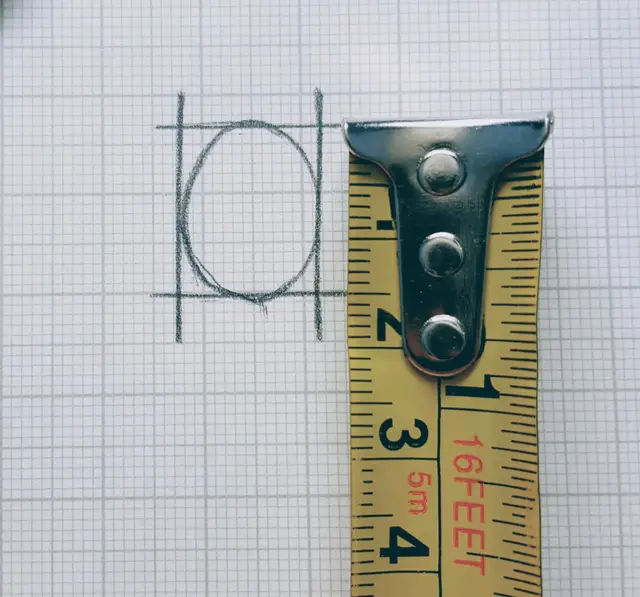 A ruler measuring the width of a locket.